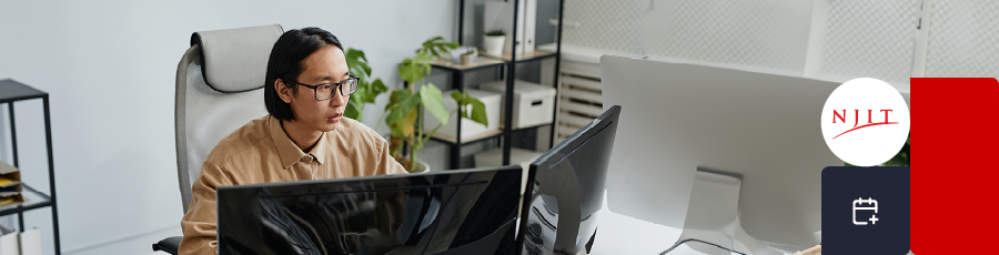 Person at a desk with multiple monitors, NJIT logo, and office decor.

